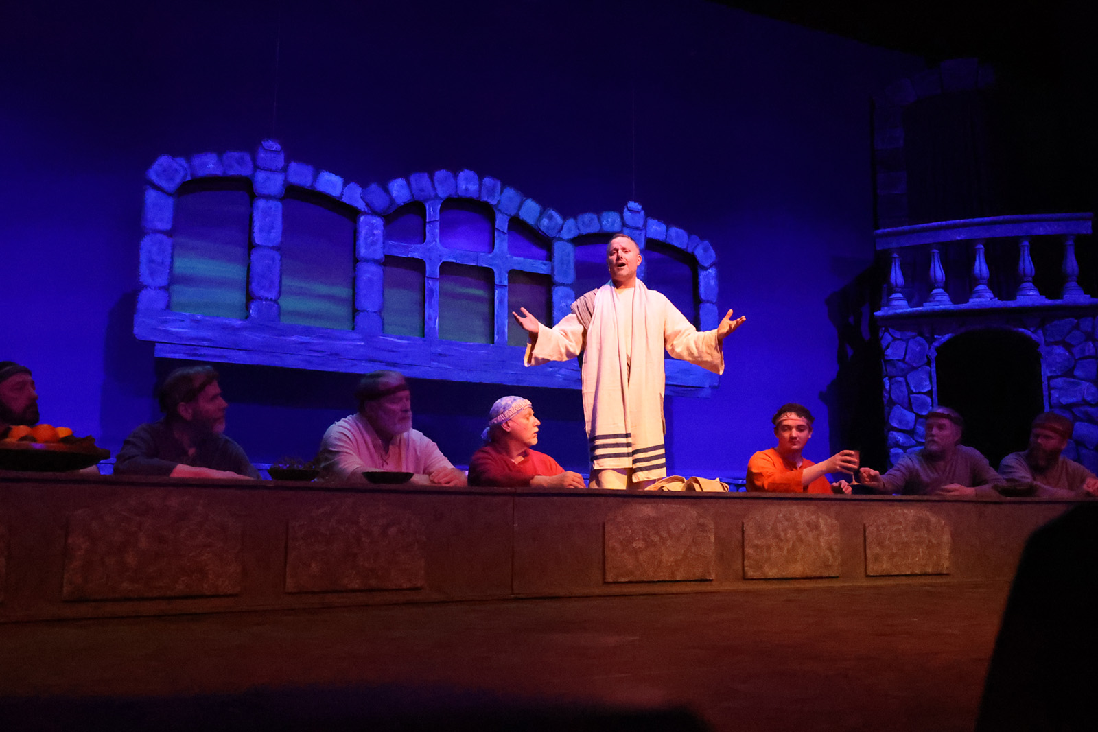 Jesus speaks to apostles seated at a table.